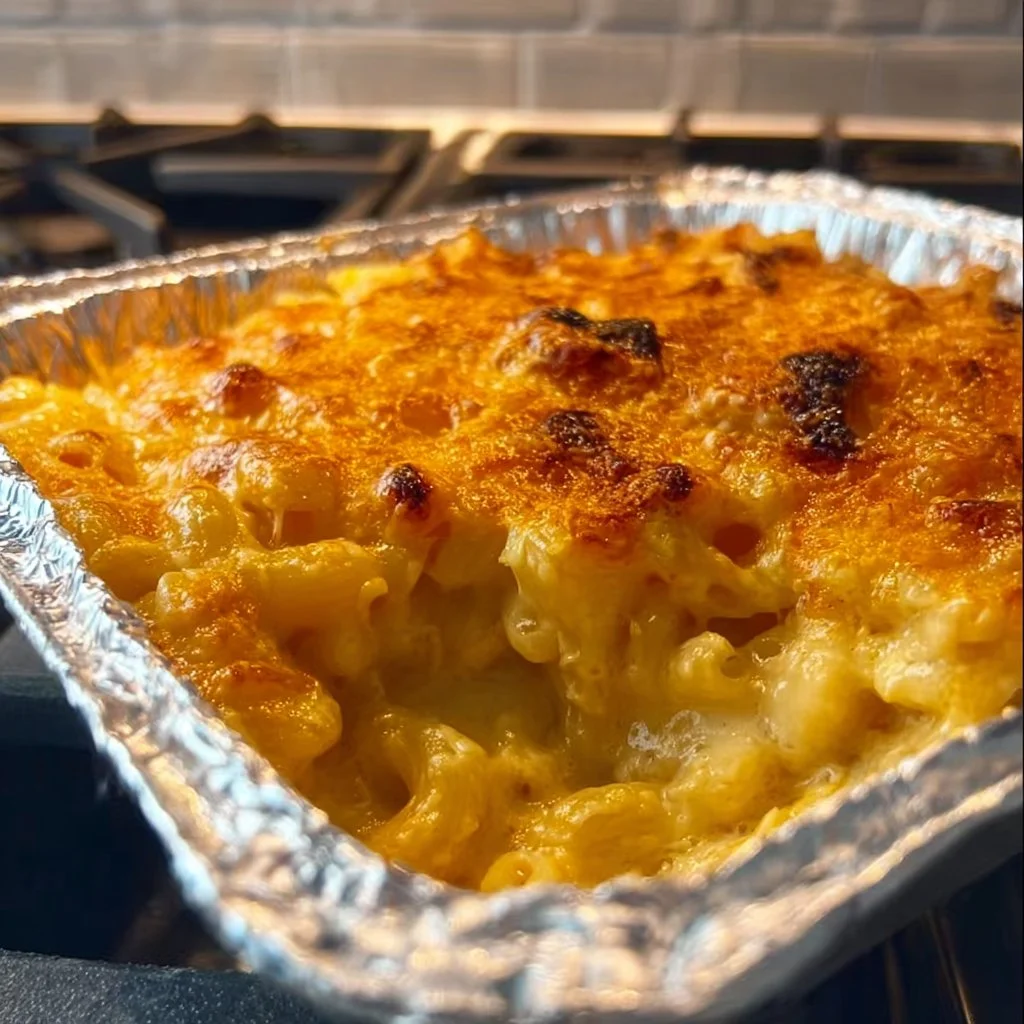 Creamy macaroni and cheese served in a bowl with a sprinkle of herbs