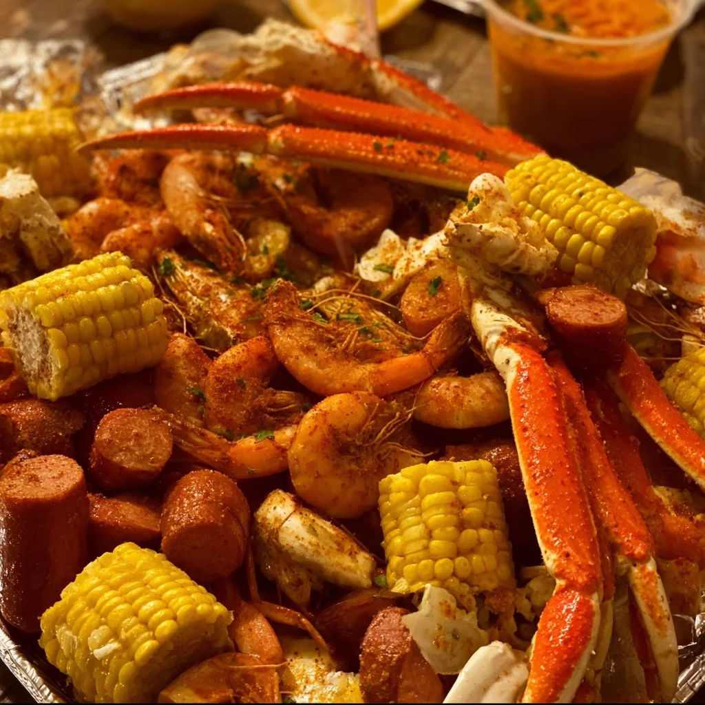 A vibrant Seafood Boil with shrimp, crab, and vegetables served on a picnic table.