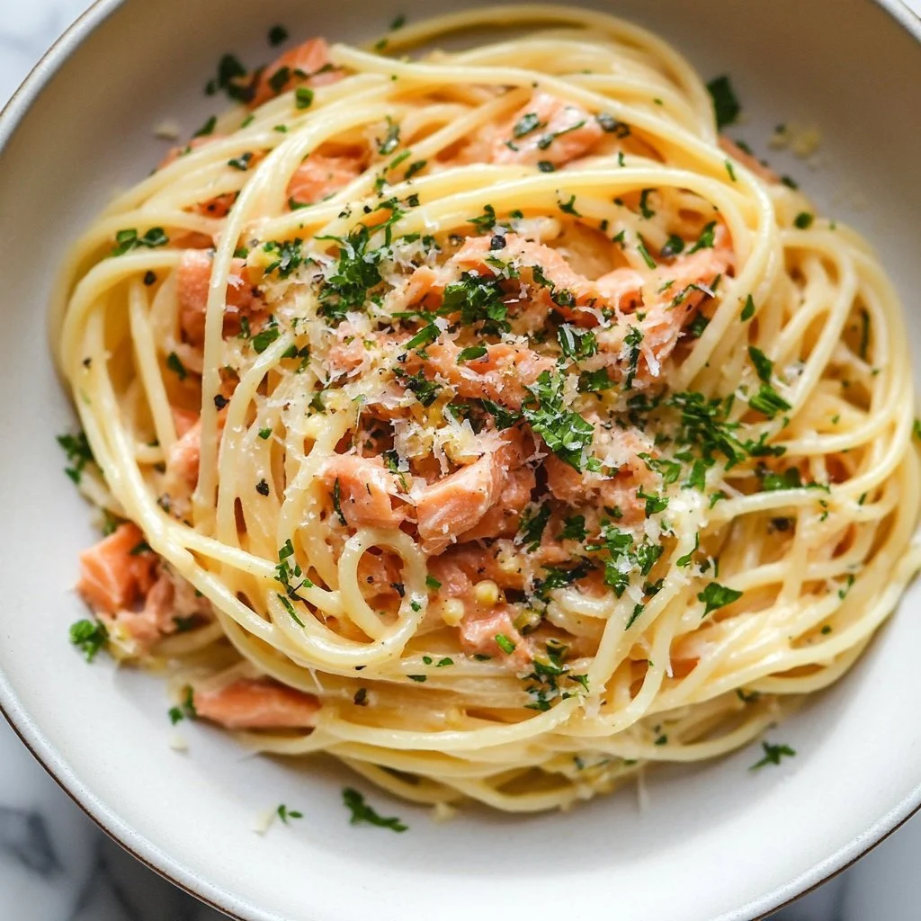 Plate of canned salmon pasta topped with herbs and cheese